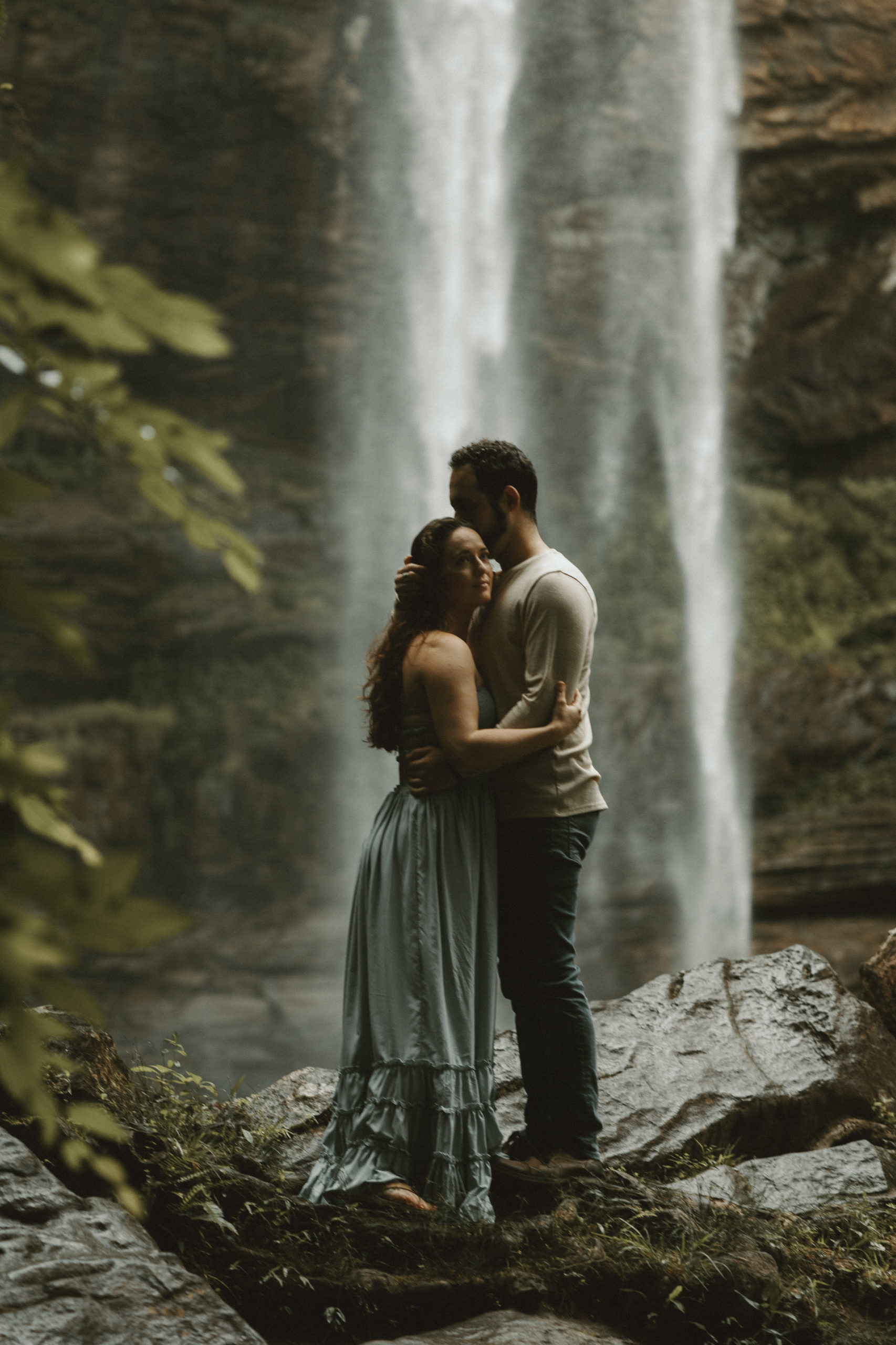 man and women embracing in waterfall