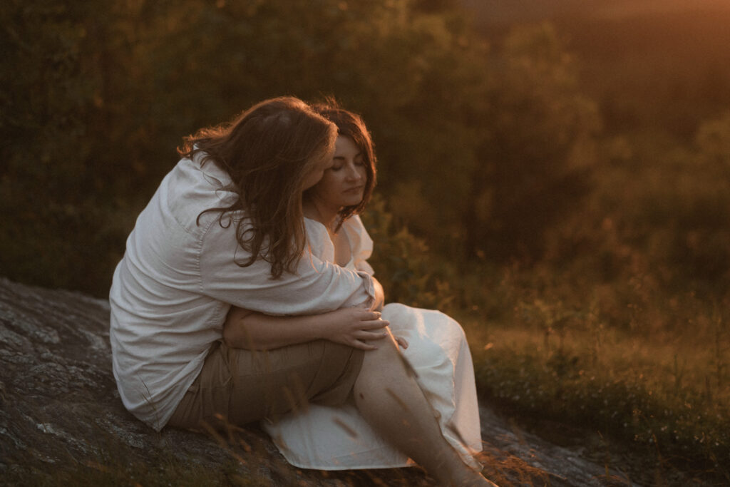 Newlyweds holding hands at golden hour on the Blue Ridge Parkway with panoramic mountain views in Western North Carolina.