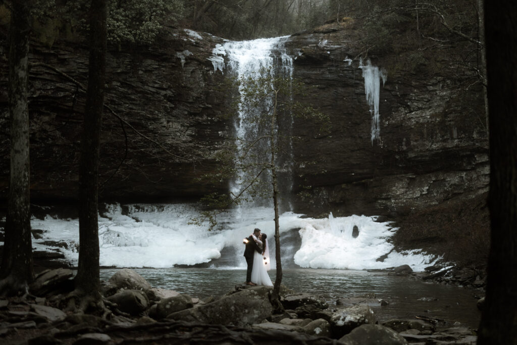 Bride and groom sharing a quiet moment in front of a waterfall during their Cloudland Canyon State Park elopement in winter