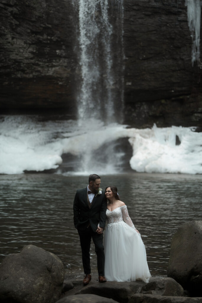 Bride and groom sharing a quiet moment in front of a waterfall during their Cloudland Canyon State Park elopement in winter