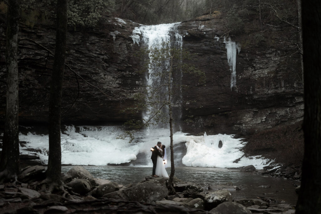 Bride and groom sharing a quiet moment in front of a waterfall during their Cloudland Canyon State Park elopement in winter