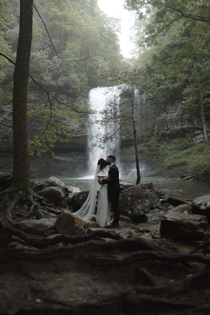 Bride and groom sharing a quiet moment in front of a waterfall during their Cloudland Canyon State Park elopement.