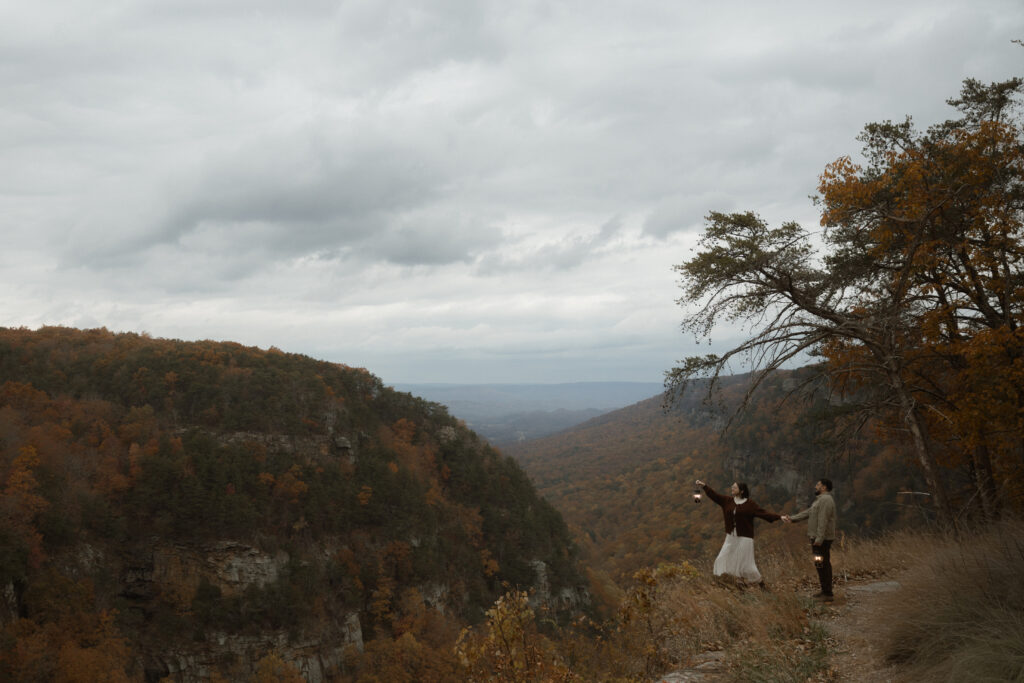 Engaged couple walking together during a fall engagement session at Cloudland Canyon State Park surrounded by autumn foliage.