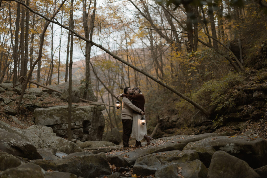 Couple embracing at a scenic overlook during their fall engagement session at Cloudland Canyon State Park.
