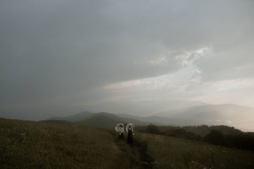 Bride and groom embracing on a mountaintop in Pisgah National Forest near Asheville at golden hour.