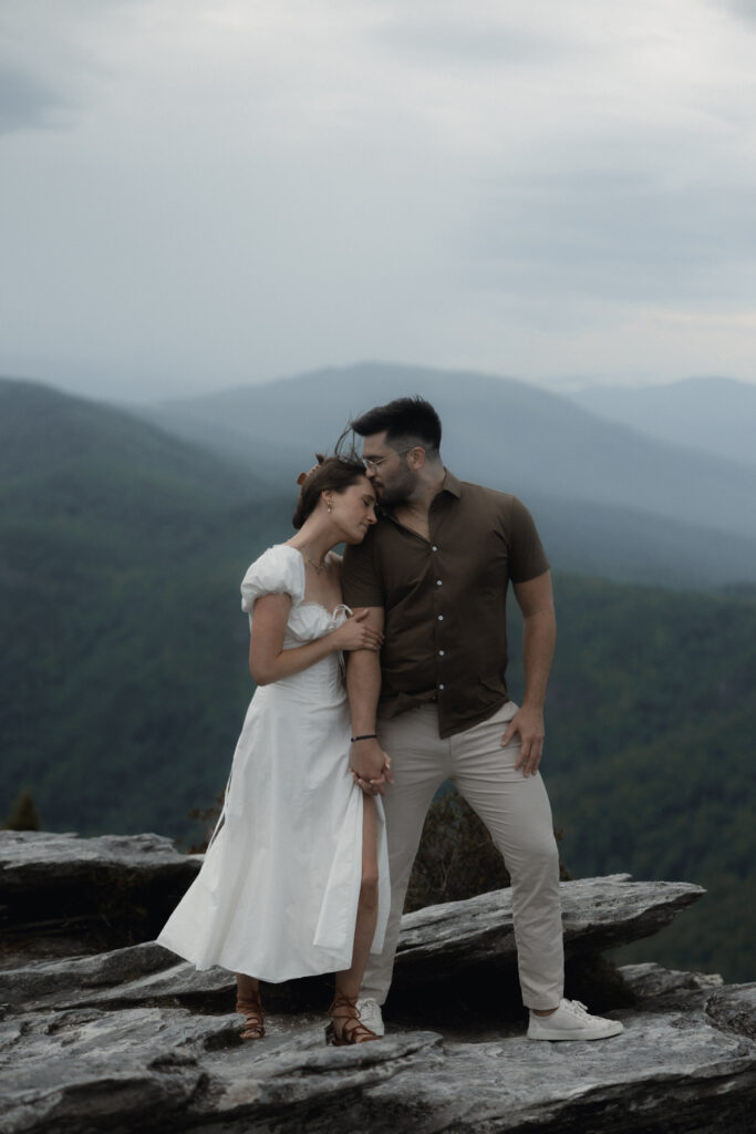Couple embracing in the rain during a moody engagement session at Linville Gorge near Asheville, North Carolina
