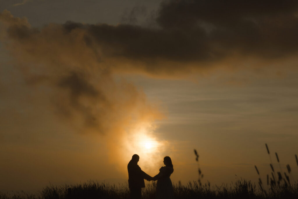 Bride and groom embracing on a mountaintop in Pisgah National Forest near Asheville at golden hour.