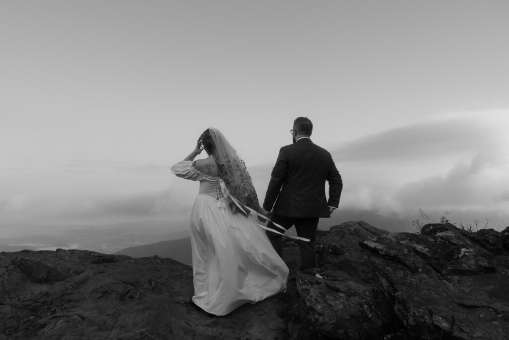 An intimate elopement on Upper Hawksbill Trail in Shenandoah National Park, Virginia. The couple hiked to the summit at sunrise, exchanging vows in a foggy, magical setting with breathtaking mountain views and their closest family and friends