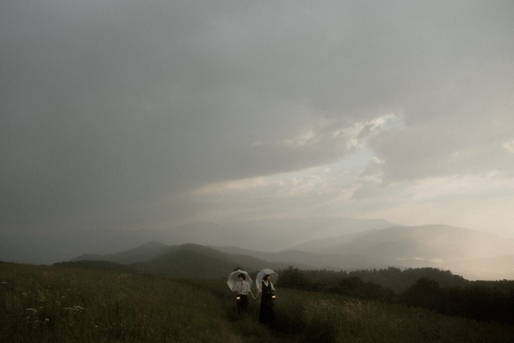 Couple during whimsical Asheville engagement session on Max Patch Western North Carolina mountain at sunset.