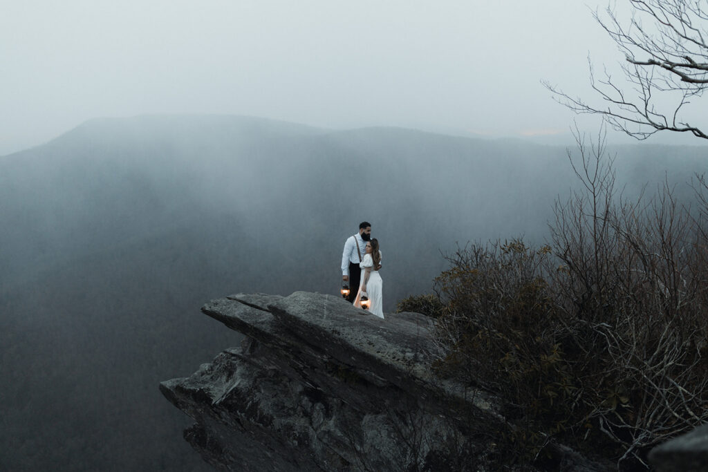 Couple walking along a misty mountain trail in Nantahala National Forest during a moody forest elopement.