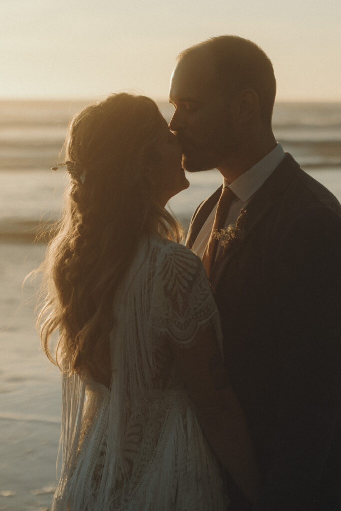 Bride and groom holding hands on Ruby Beach at golden hour during a summer Olympic National Park elopement with dramatic sea stacks and warm coastal light.