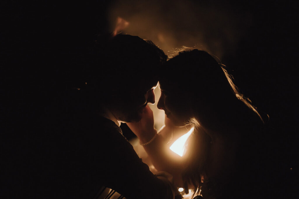 Bride and groom during their Asheville summer elopement on the Blue Ridge Parkway surrounded by a campfire