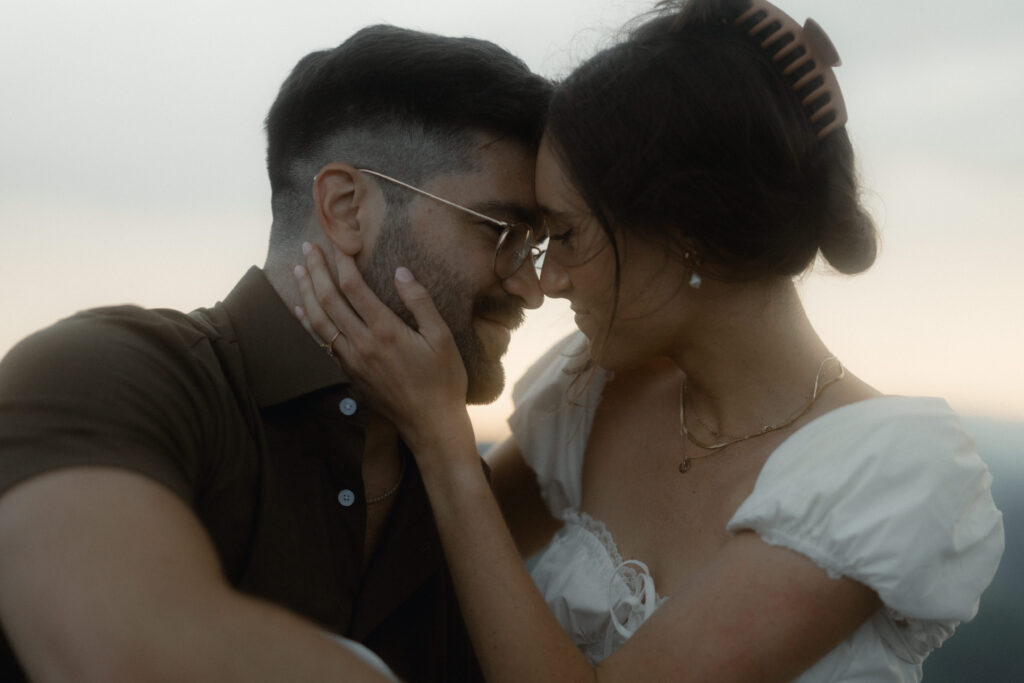 Couple embracing in the rain during a moody engagement session at Linville Gorge near Asheville, North Carolina
