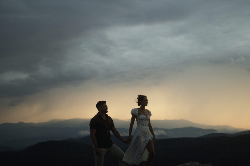 Couple embracing in the rain during a moody engagement session at Linville Gorge near Asheville, North Carolina