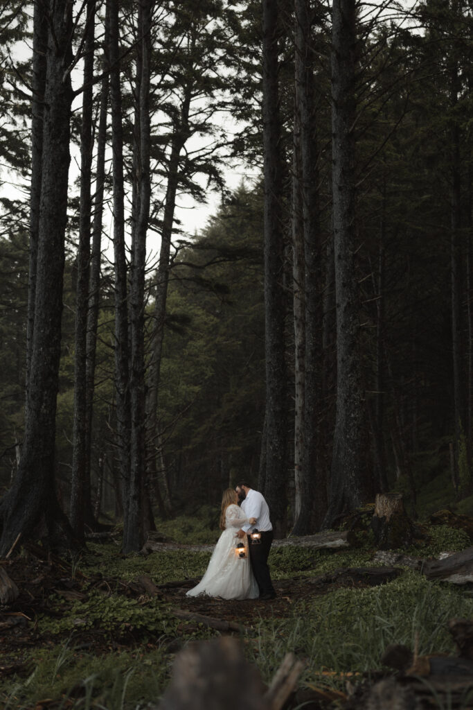 Bride and groom embracing on Rialto Beach during a foggy sunset elopement in Olympic National Park with dramatic sea stacks and waves crashing along the Washington coast.