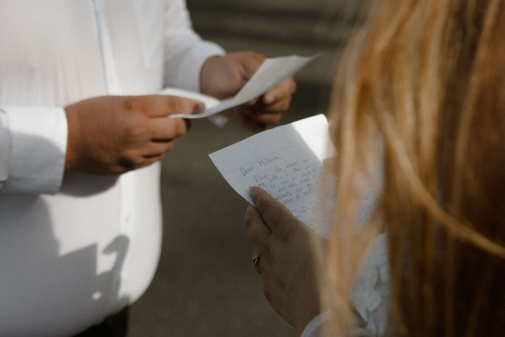Couple exchanging vows on Rialto Beach in Olympic National Park with mist rolling in around sea stacks and waves under overcast skies.