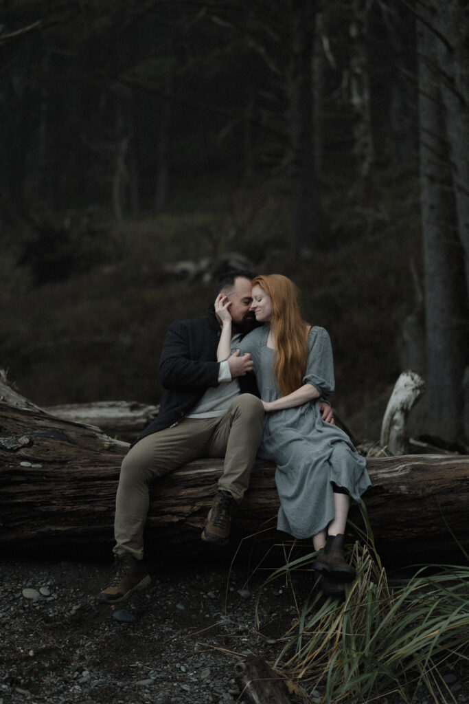 Couple embracing during a foggy elopement on Rialto Beach in Olympic National Park, surrounded by sea stacks and soft coastal mist.
