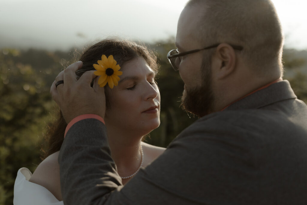 Cinematic golden hour portrait of couple in drifting mountain fog during their Asheville elopement ceremony