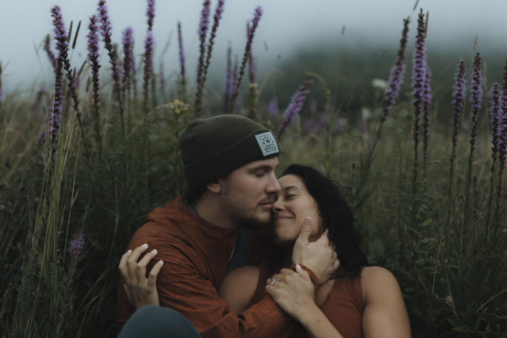 Bride and groom surrounded by thick mountain fog and wildflowers during their Blue Ridge Parkway elopement near Asheville