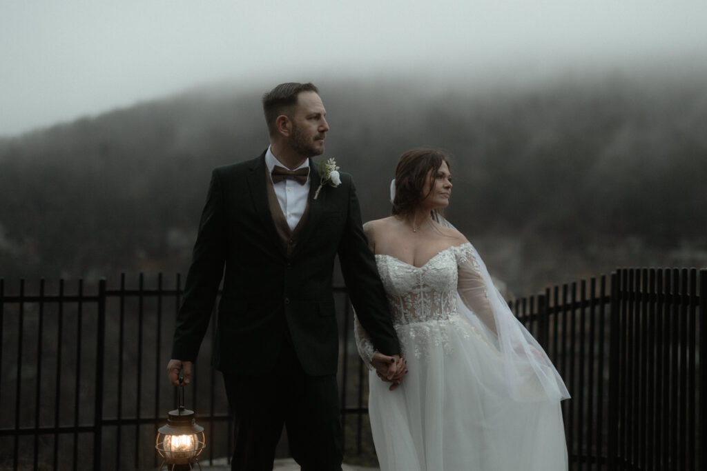 Bride and groom walking along a foggy overlook during a winter elopement at Cloudland Canyon State Park in Georgia